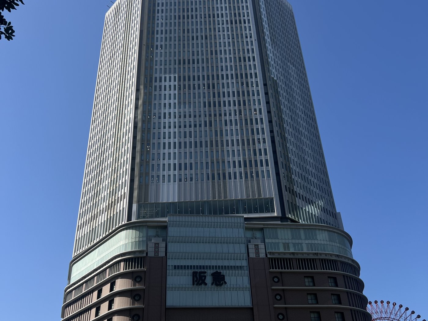 Osaka's Hankyu tower against a clear winter sky — dense, vertical, and an easy train ride from onsen country or Hokkaido's ski slopes.